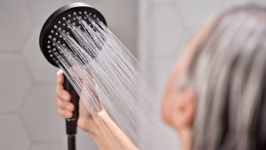 A woman using the hansgrohe Raindance Handshower. point it towards her as she uses it to wash her hair #AllMyFeels